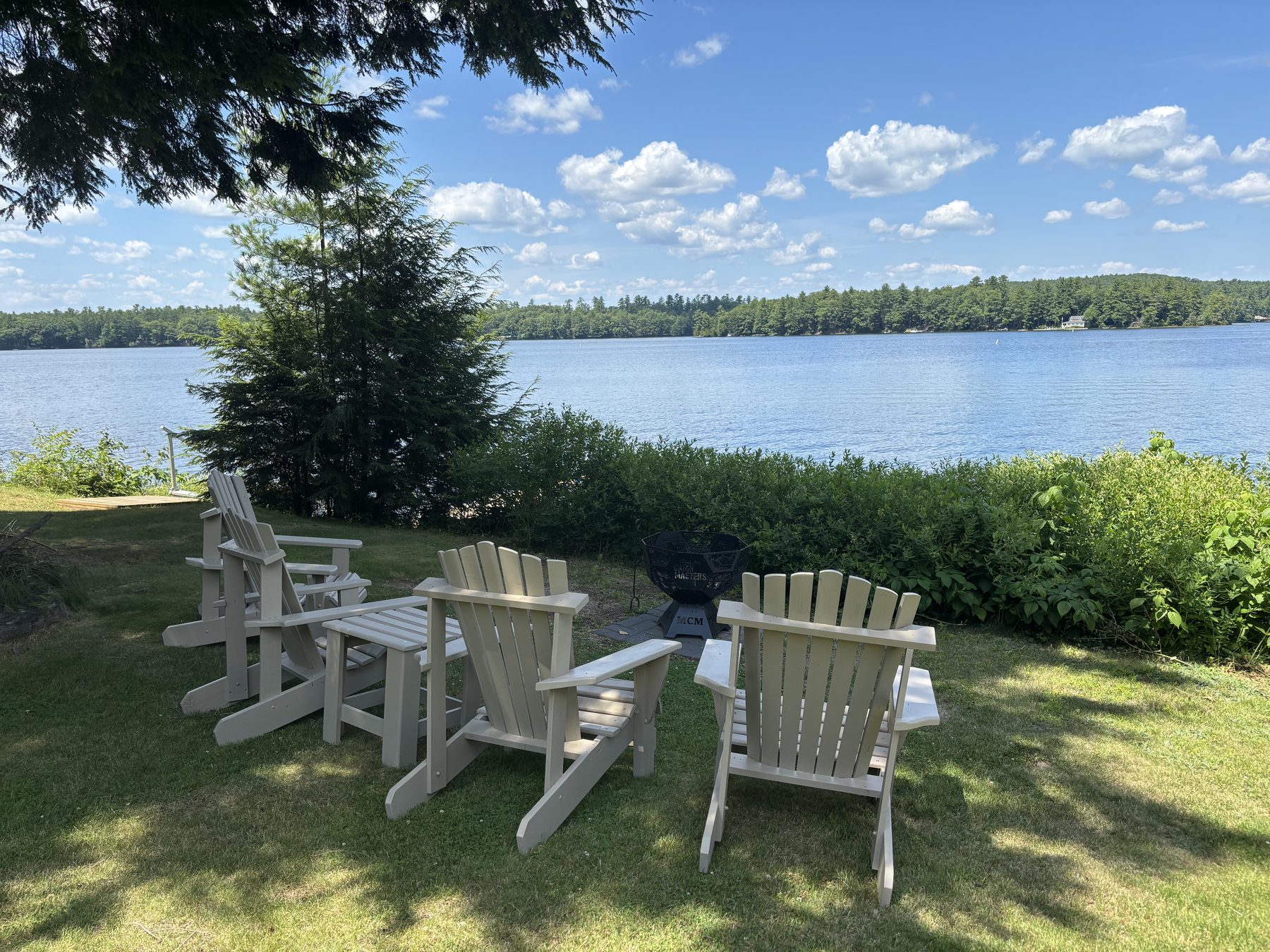 Adirondack chairs and fire pit at the lake's edge